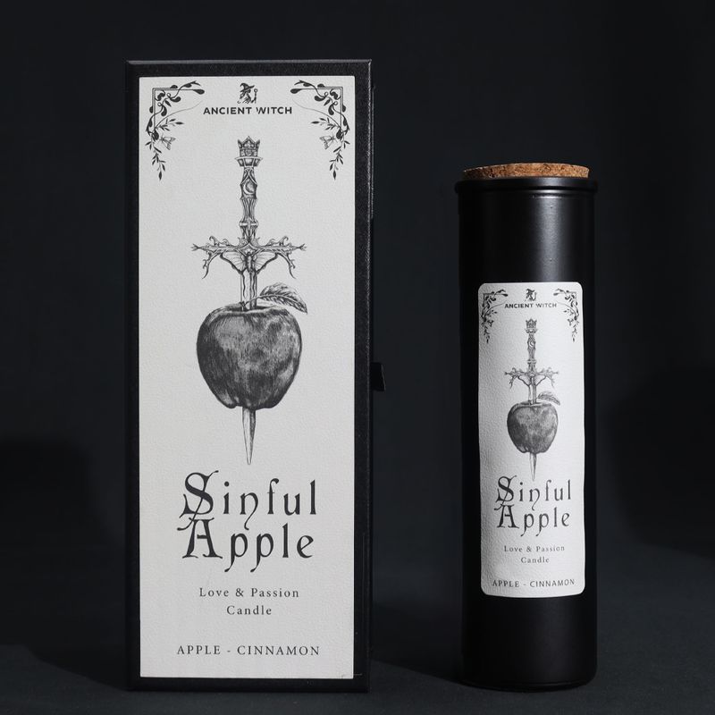 Sinful Apple rituele kaars en appel-geschenkdoos die door een rituele dolk is doorboord op een zwarte achtergrond