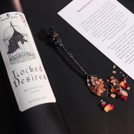 Close-up van het Locked Desires-kaarslabel met een vleermuis in een kooi